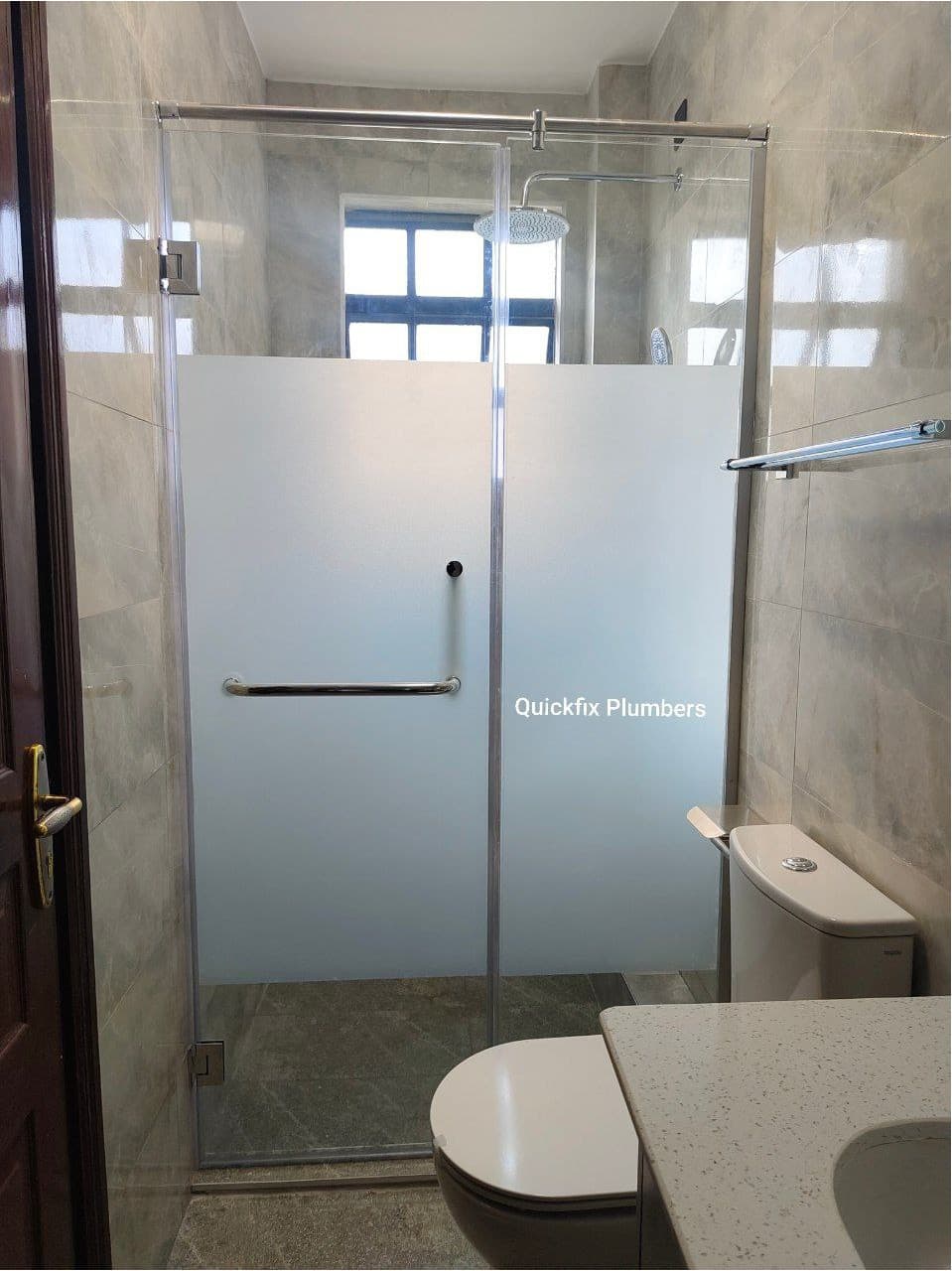Frameless glass shower enclosure with privacy film