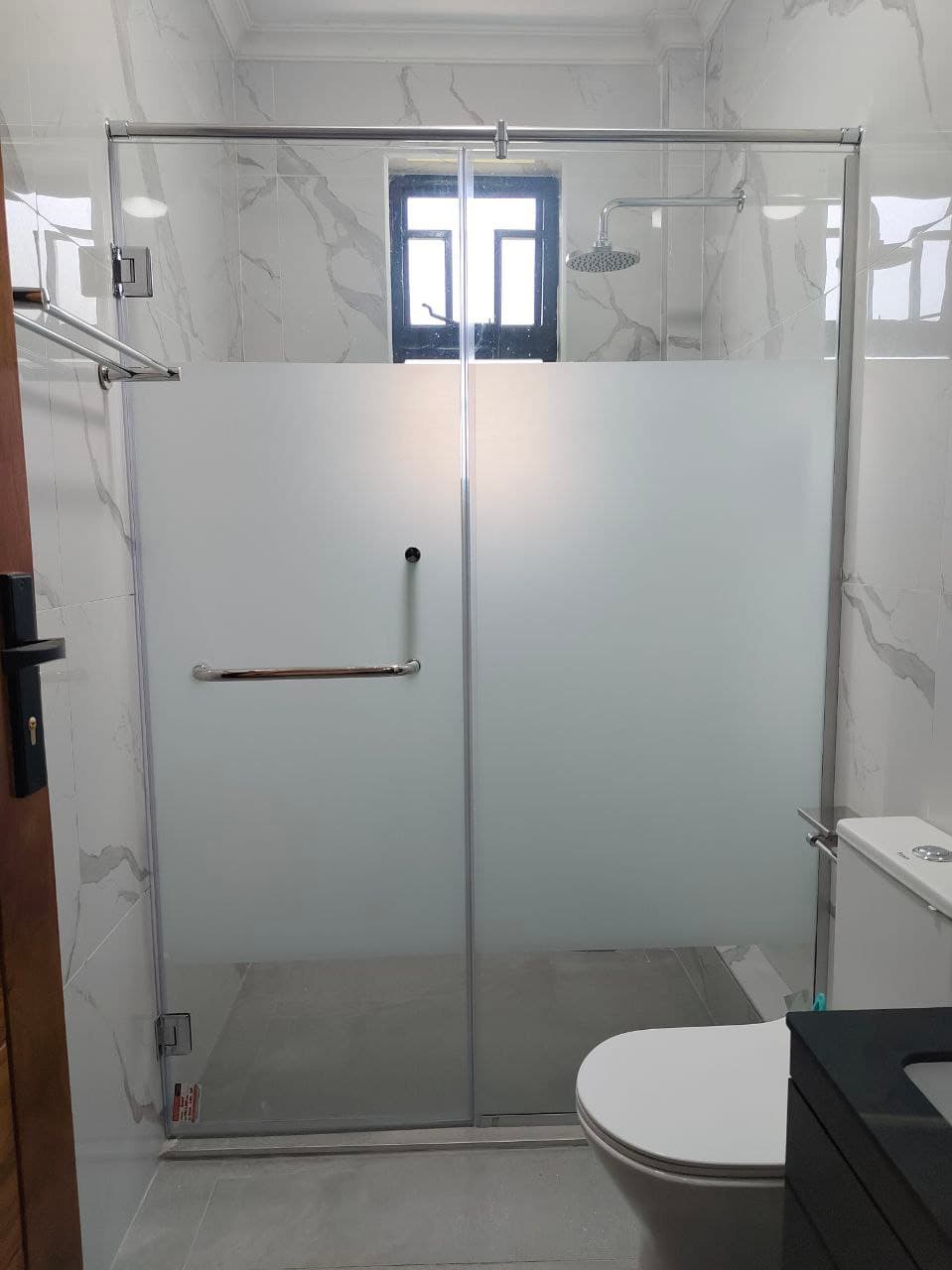 Glass shower enclosure wall to wall with swing door